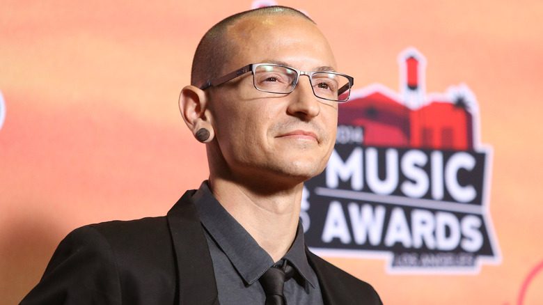 Chester Bennington portant des lunettes, un costume et une cravate