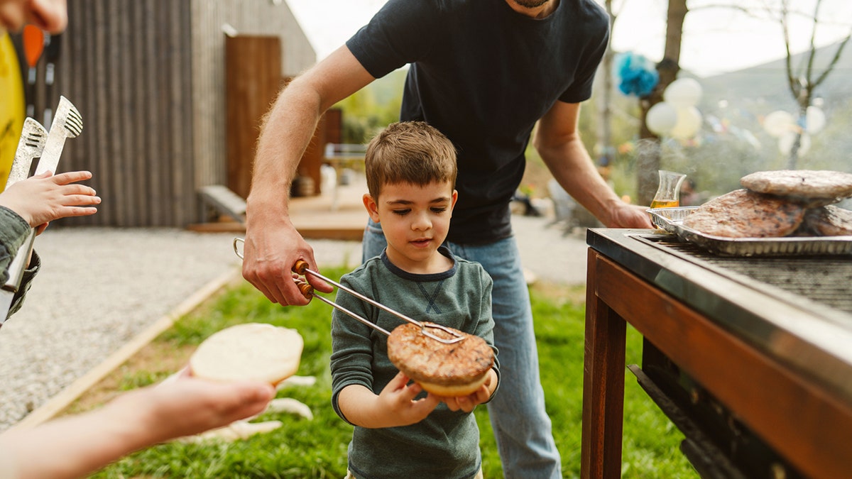 Famille préparant des hamburgers sur le grill