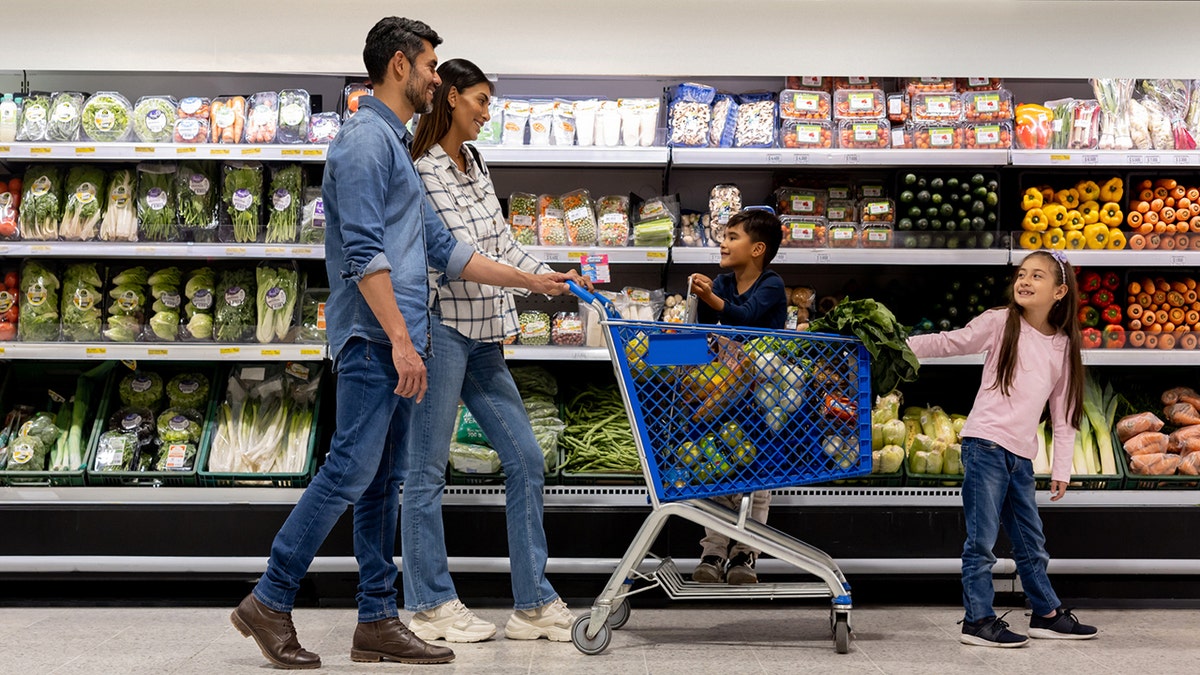 Famille utilisant un chariot pendant les courses