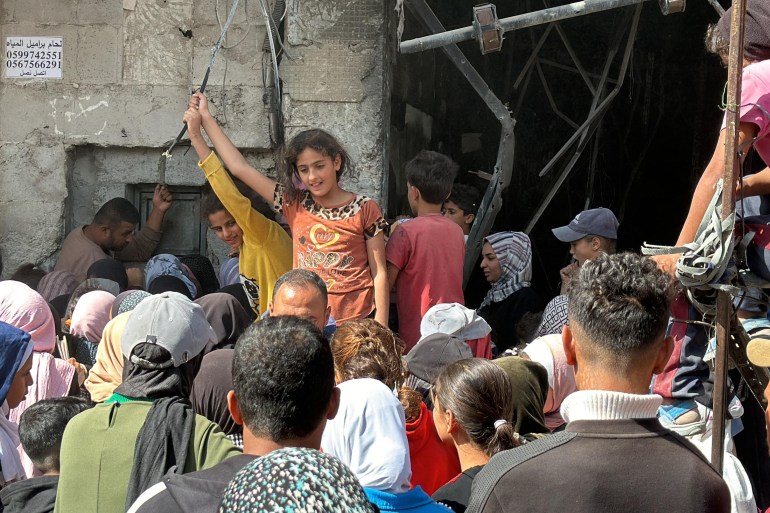 Des hommes, femmes et enfants se bousculent pour obtenir du pain dans une situation de crise à Gaza.