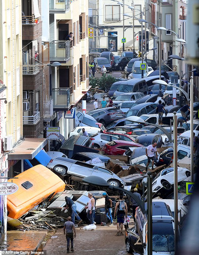 Des voitures endommagées sont empilées dans une rue au sud de Valence.