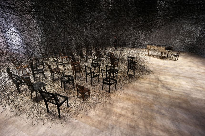 Chiharu Shiota In Silence 2002 2024 Piano brûlé, chaise brûlée, fil noir Alcantara Vue de l’installation Shiota Chiharu The Soul Trembles, Mori Art Museum, Tokyo, 2019